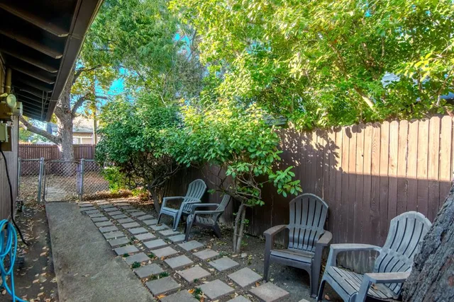 a view of a chairs and table in the back yard of the house