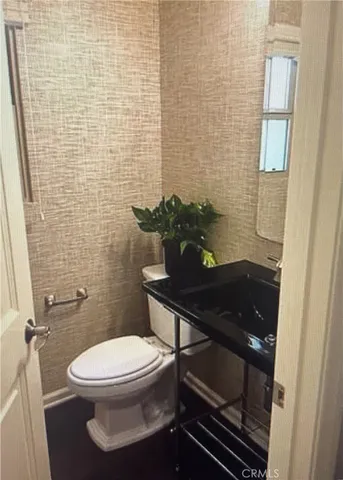 a bathroom with a toilet a sink and mirror