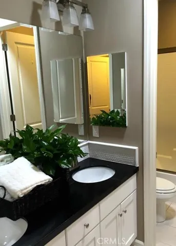 a bathroom with a sink a toilet and mirror