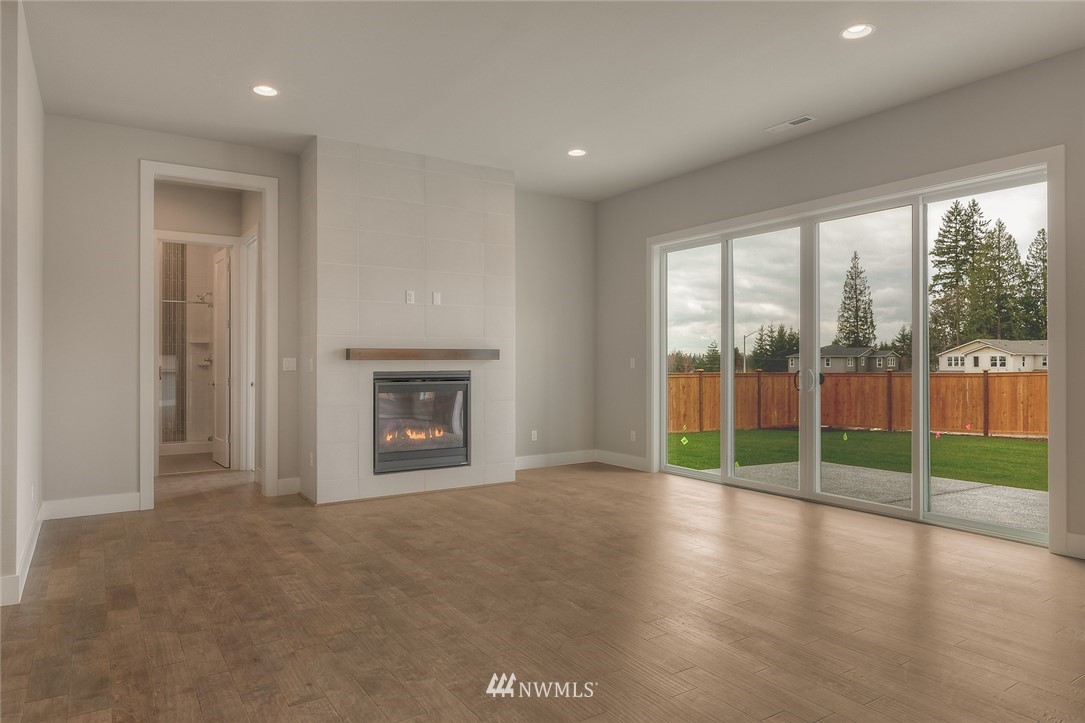 3317 219th Place Southeast, Unit 30 Bothell, WA 98021 - Photo 6 of 25 a view of empty room with wooden floor and fireplace