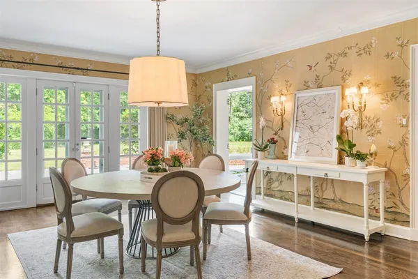 a dining room with furniture a chandelier and wooden floor