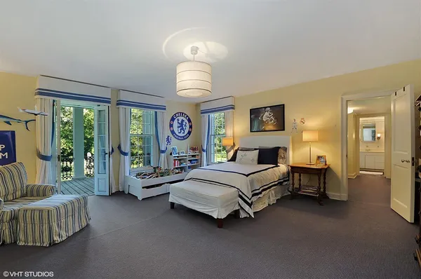 a spacious bedroom with a bed and a chandelier
