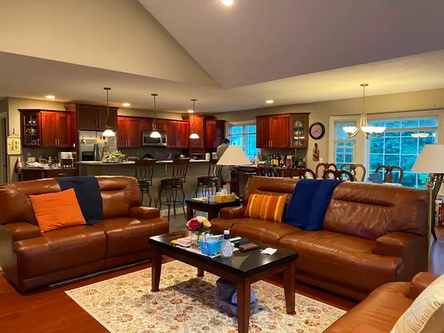 a living room with furniture a kitchen and a dining table with kitchen view