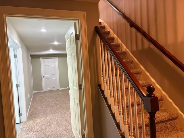 a view of staircase with wooden floor and white walls