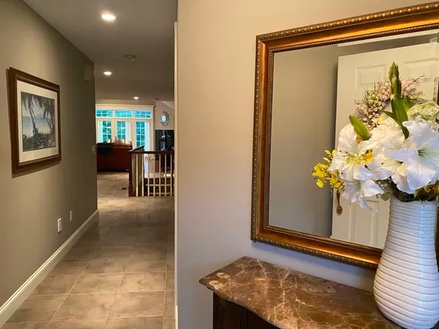 a view of a hallway with wooden floor and a potted plant