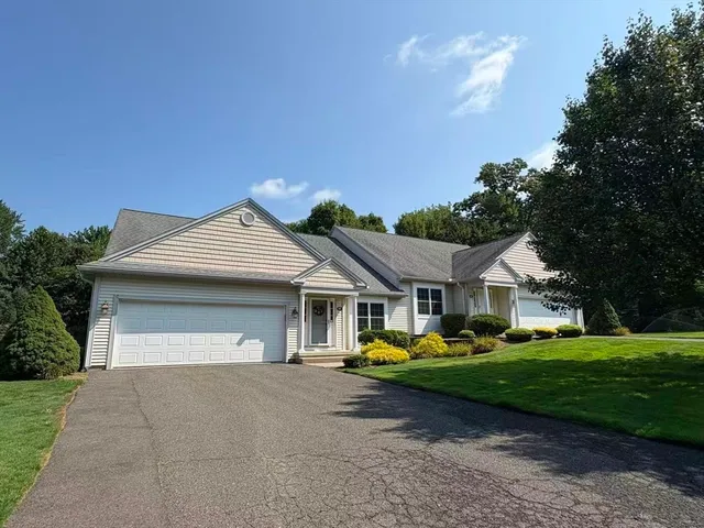 a front view of a house with a garden and trees