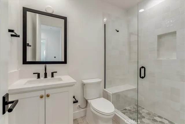 a bathroom with a toilet sink vanity and mirror