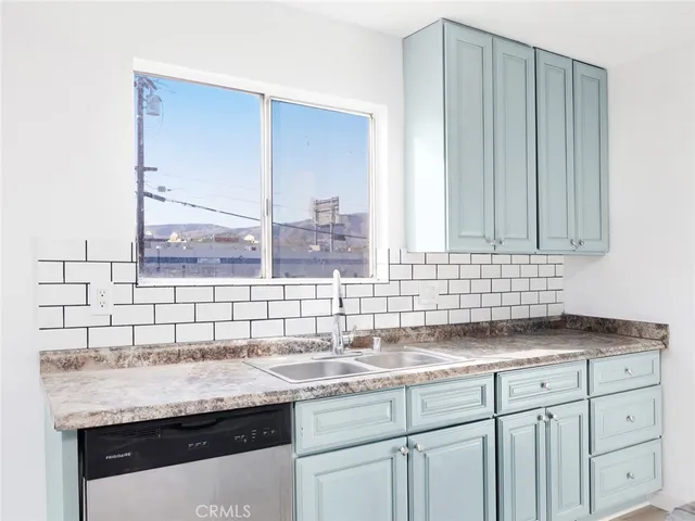 a kitchen with granite countertop a sink and a wooden floor
