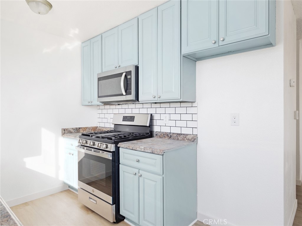 38423 10th Place East, Unit 3 Palmdale, CA 93550 - Photo 13 of 27 a white stove top oven sitting inside of a kitchen