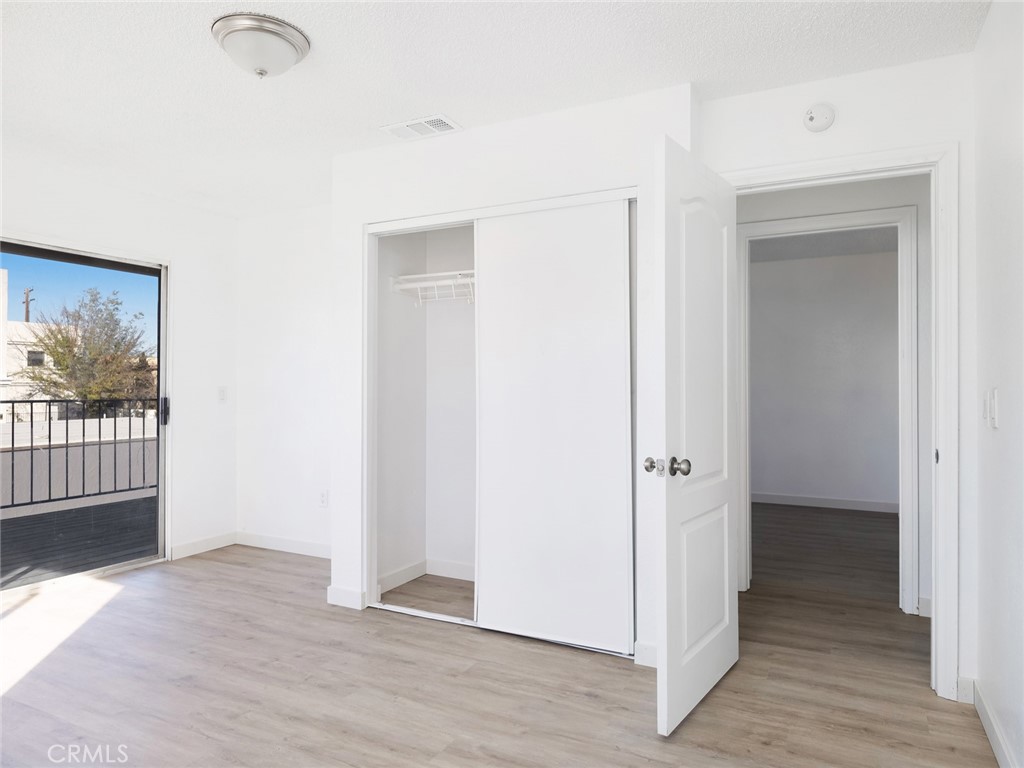 38423 10th Place East, Unit 3 Palmdale, CA 93550 - Photo 21 of 27 a view of a hallway with wooden floor and a living room