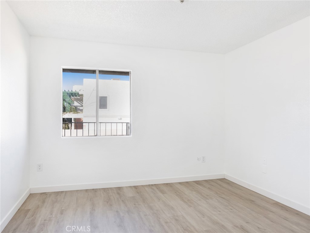 38423 10th Place East, Unit 3 Palmdale, CA 93550 - Photo 23 of 27 an empty room with wooden floor and windows