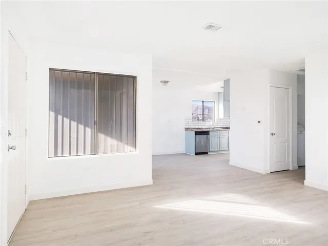 an empty room with wooden floor and a ceiling fan
