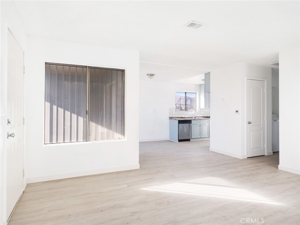 38423 10th Place East, Unit 3 Palmdale, CA 93550 - Photo 7 of 27 an empty room with wooden floor and a ceiling fan
