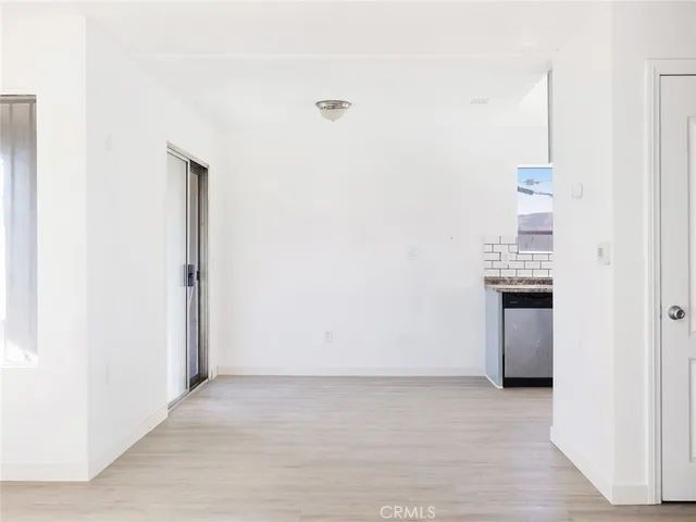 a view of a room with wooden floor and a bathroom