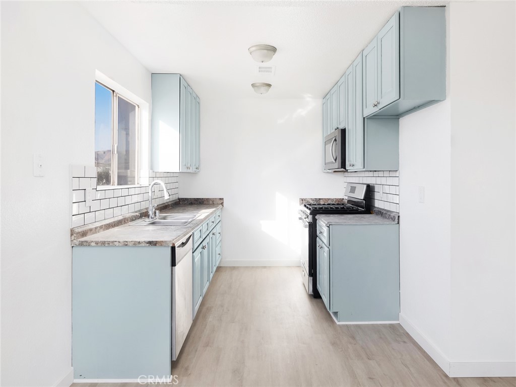 38423 10th Place East, Unit 3 Palmdale, CA 93550 - Photo 10 of 27 a kitchen with stainless steel appliances granite countertop a sink stove and refrigerator