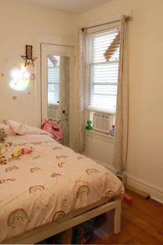 a bedroom with a bed and wooden floor