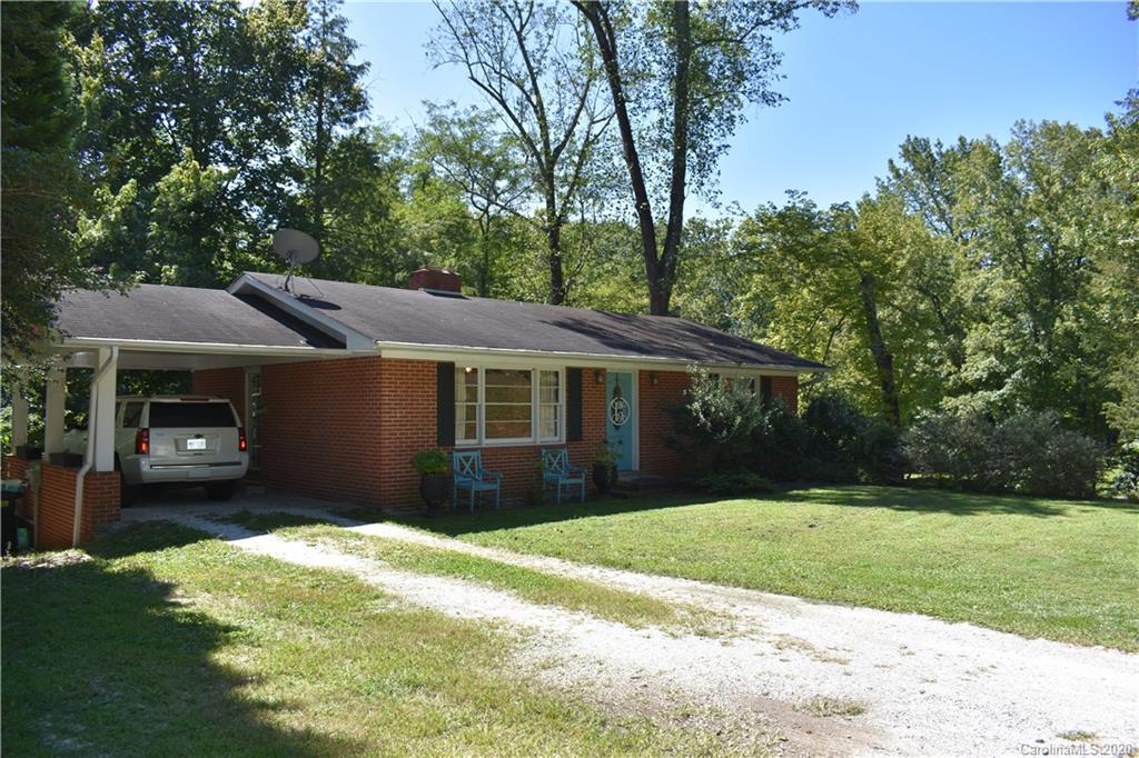 91 Country Club Road Tryon, NC 28782 - Photo 1 of 24 a front view of a house with a yard and garage