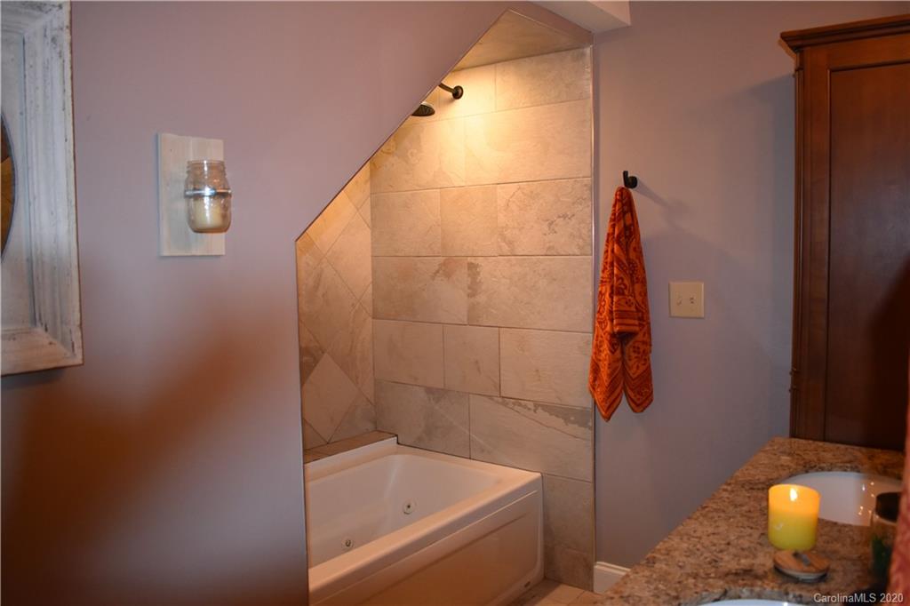 91 Country Club Road Tryon, NC 28782 - Photo 14 of 24 a bathroom with a bathtub and a shower