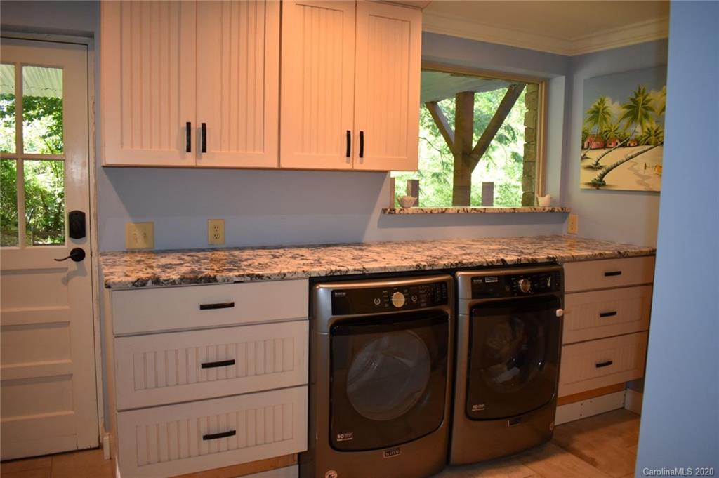 91 Country Club Road Tryon, NC 28782 - Photo 17 of 24 a kitchen with granite countertop white cabinets and a stove
