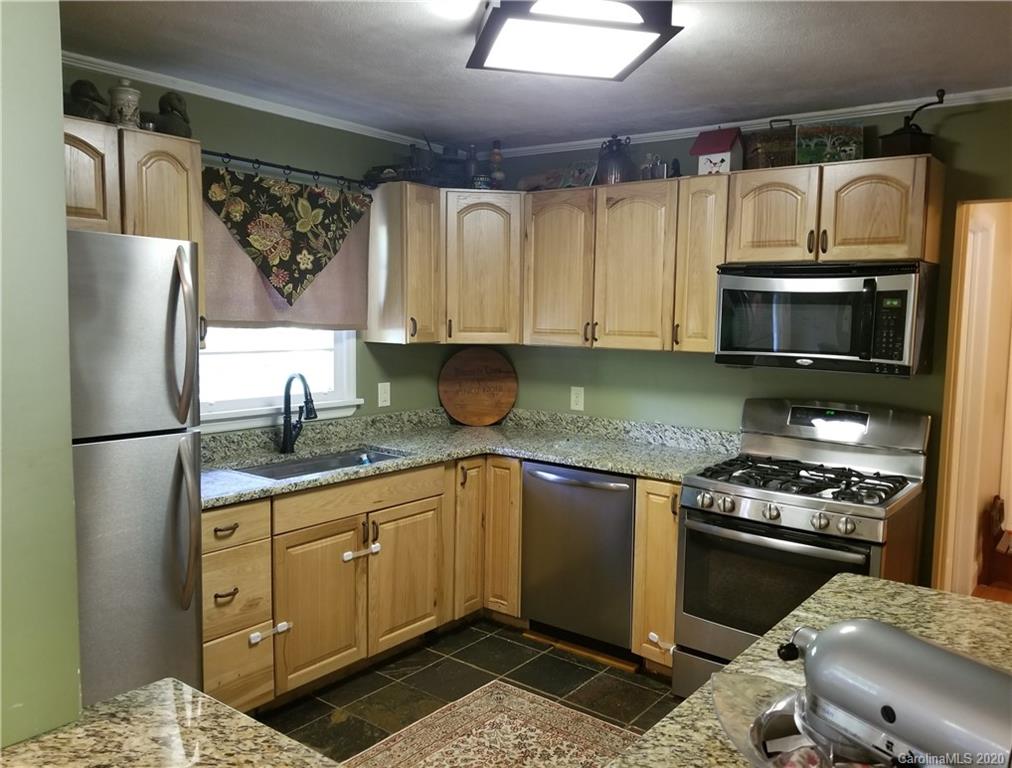 91 Country Club Road Tryon, NC 28782 - Photo 5 of 24 a kitchen with stainless steel appliances granite countertop a refrigerator sink and stove