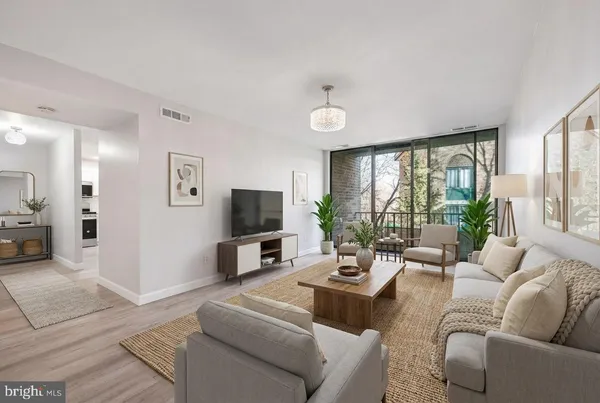 a living room with furniture a large window and a flat screen tv