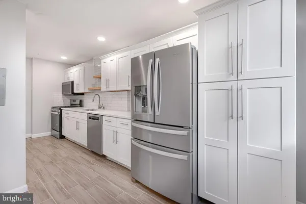 a kitchen with white cabinets and white appliances