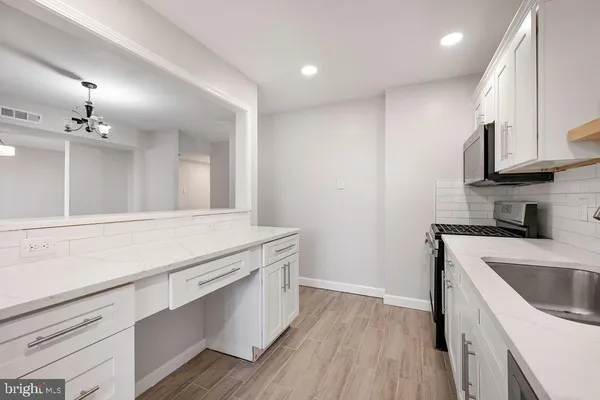 a kitchen with a sink dishwasher a stove and a refrigerator with wooden floor