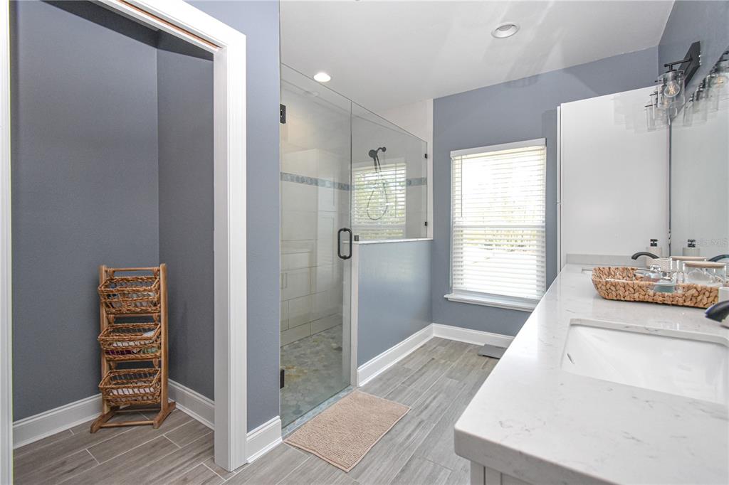 7890 Southwest 129th Avenue Cedar Key, FL 32625 - Photo 22 of 45 a spacious bathroom with a granite countertop sink a shower and a mirror