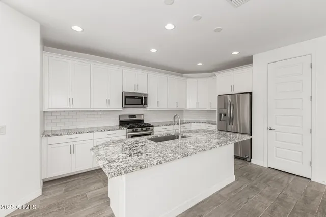 a kitchen with stainless steel appliances granite countertop a refrigerator sink and cabinets