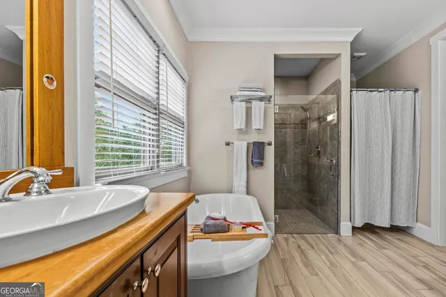 a kitchen with stainless steel appliances wooden floor and large windows