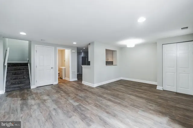 an empty room with wooden floor and closet area