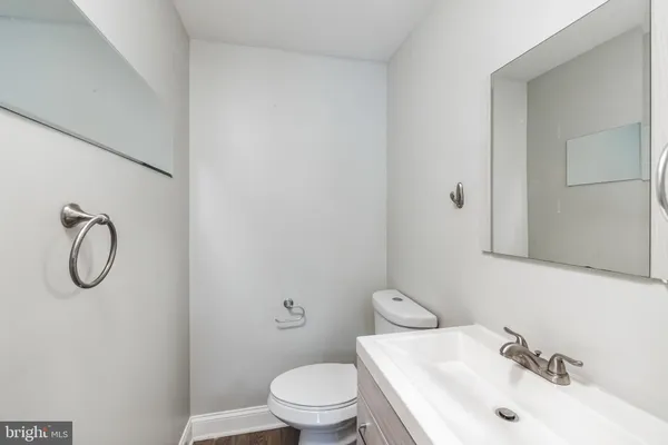 a bathroom with a toilet sink vanity and mirror