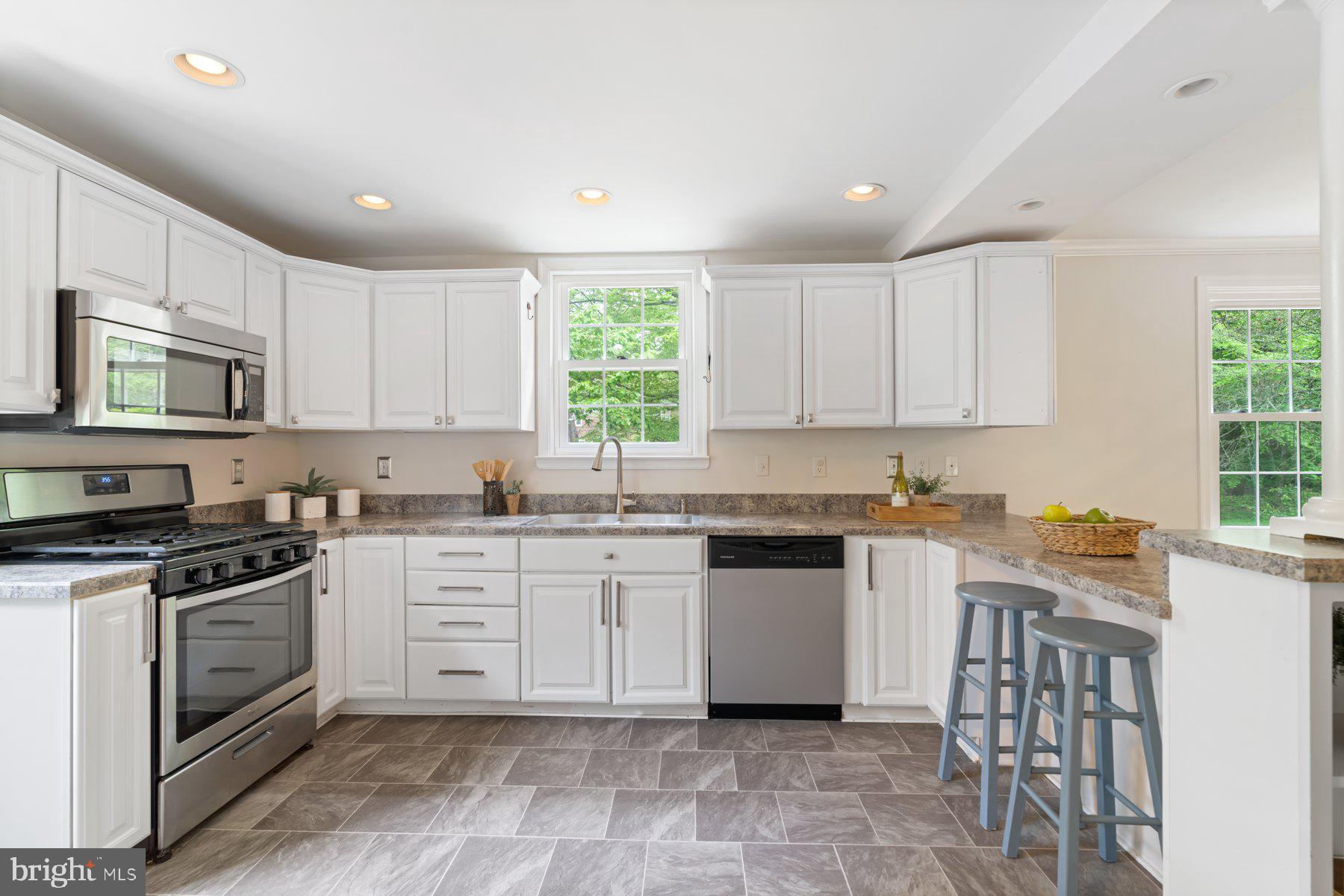 540 Brook Road Towson, MD 21286 - Photo 11 of 37 a kitchen with granite countertop white cabinets white stainless steel appliances with a sink and dishwasher