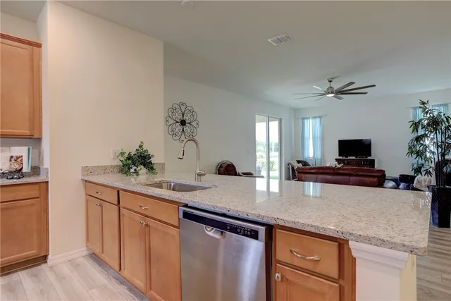a kitchen with granite countertop a sink a counter top space and cabinets