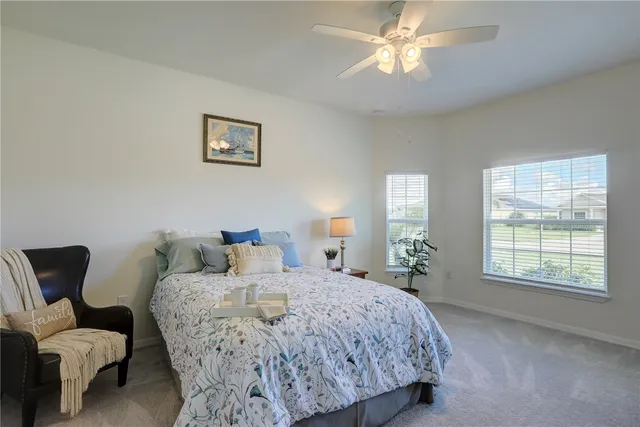 a bedroom with a bed couches chair and a window