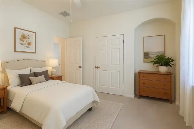 a bedroom with a bed and a potted plant