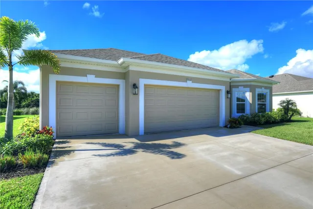 a front view of a house with a yard and a garage