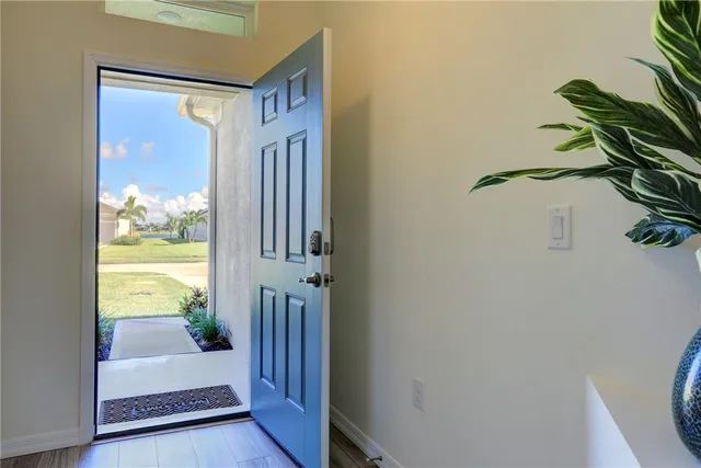a view of a hallway with wooden floor and a dining room