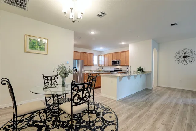 a kitchen with a dining table chairs and refrigerator