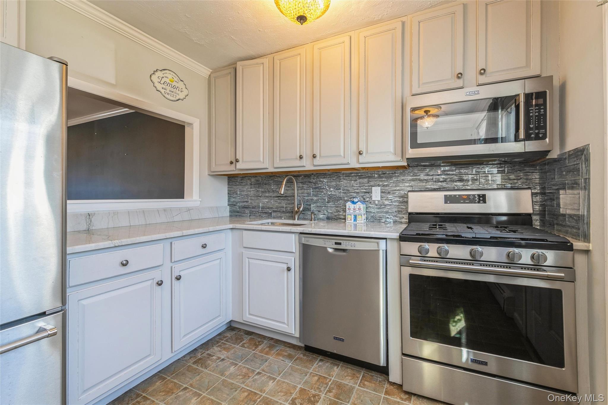 92 Cardinal Lane, Unit 92 Islip, NY 11751 - Photo 1 of 36 a kitchen with granite countertop white cabinets stainless steel appliances and sink