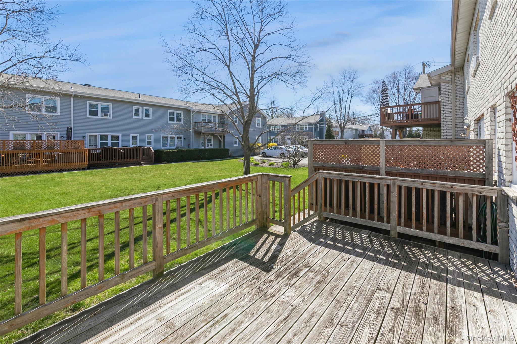 92 Cardinal Lane, Unit 92 Islip, NY 11751 - Photo 16 of 36 a view of a wooden deck with a yard