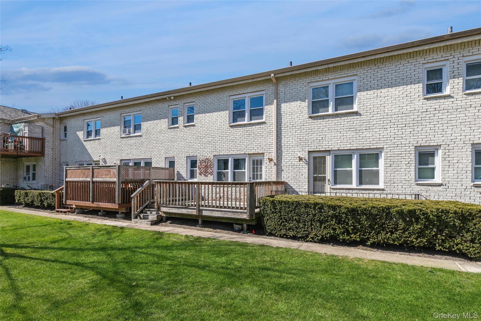 92 Cardinal Lane, Unit 92 Islip, NY 11751 - Photo 20 of 36 a front view of a house with a yard
