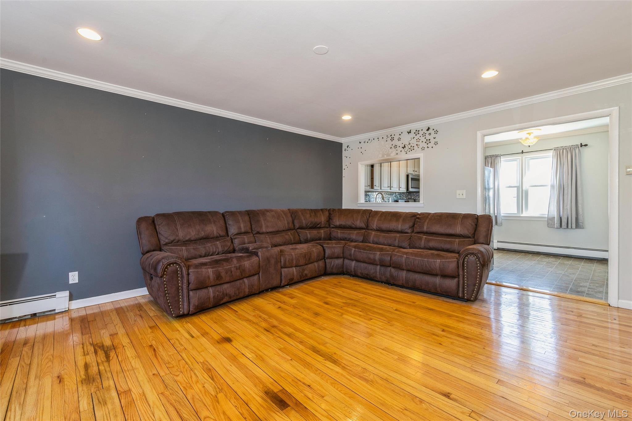 92 Cardinal Lane, Unit 92 Islip, NY 11751 - Photo 2 of 36 a living room with a couch and chandelier