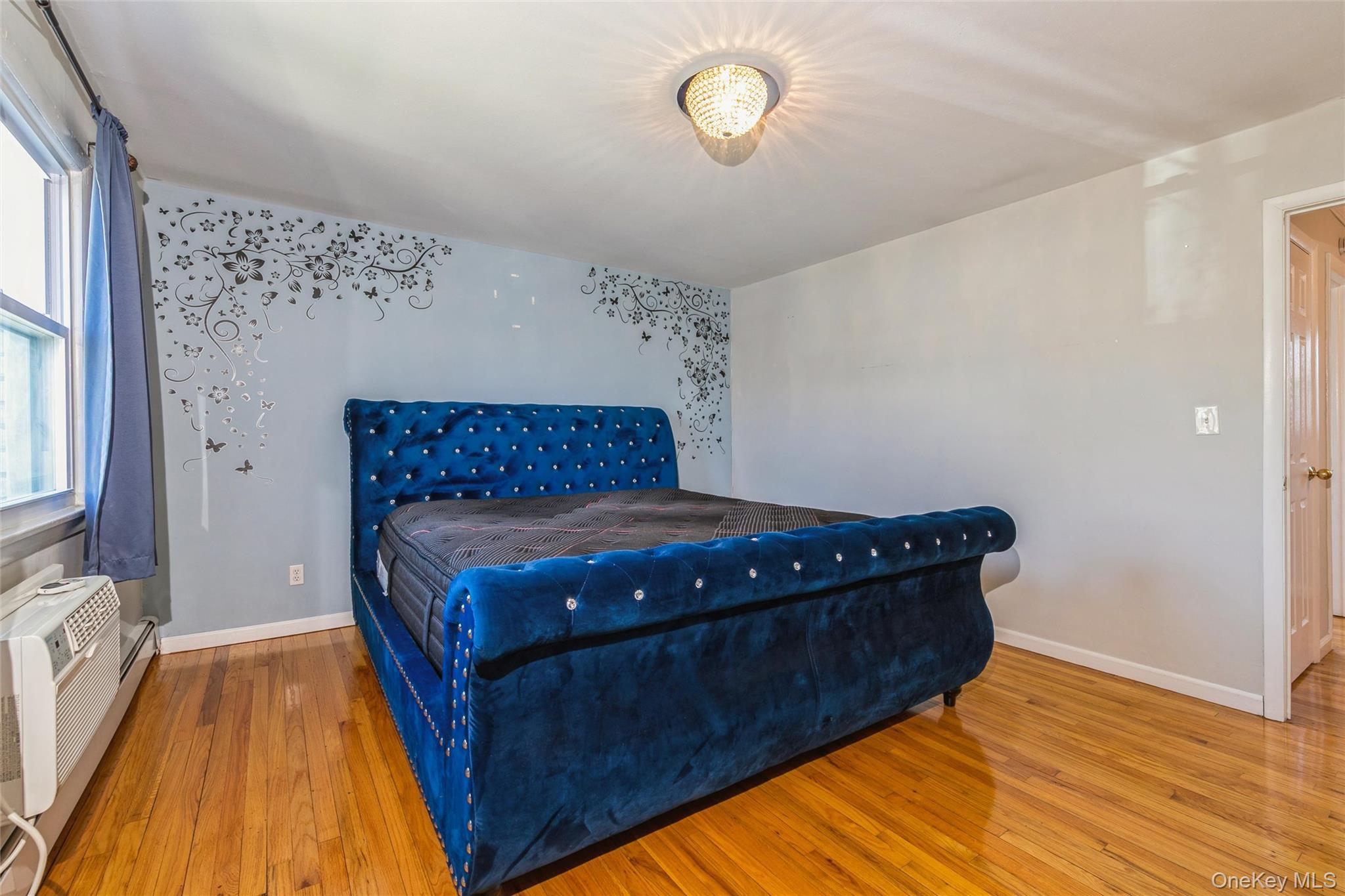 92 Cardinal Lane, Unit 92 Islip, NY 11751 - Photo 23 of 36 a bedroom with a bed and wooden floor