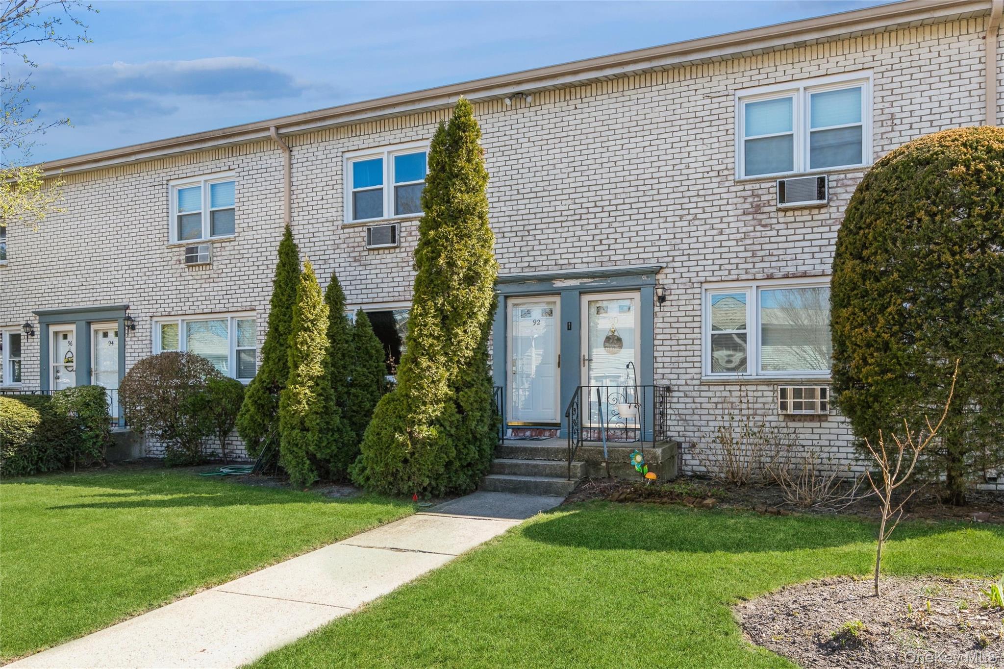 92 Cardinal Lane, Unit 92 Islip, NY 11751 - Photo 25 of 36 a front view of a house with a garden