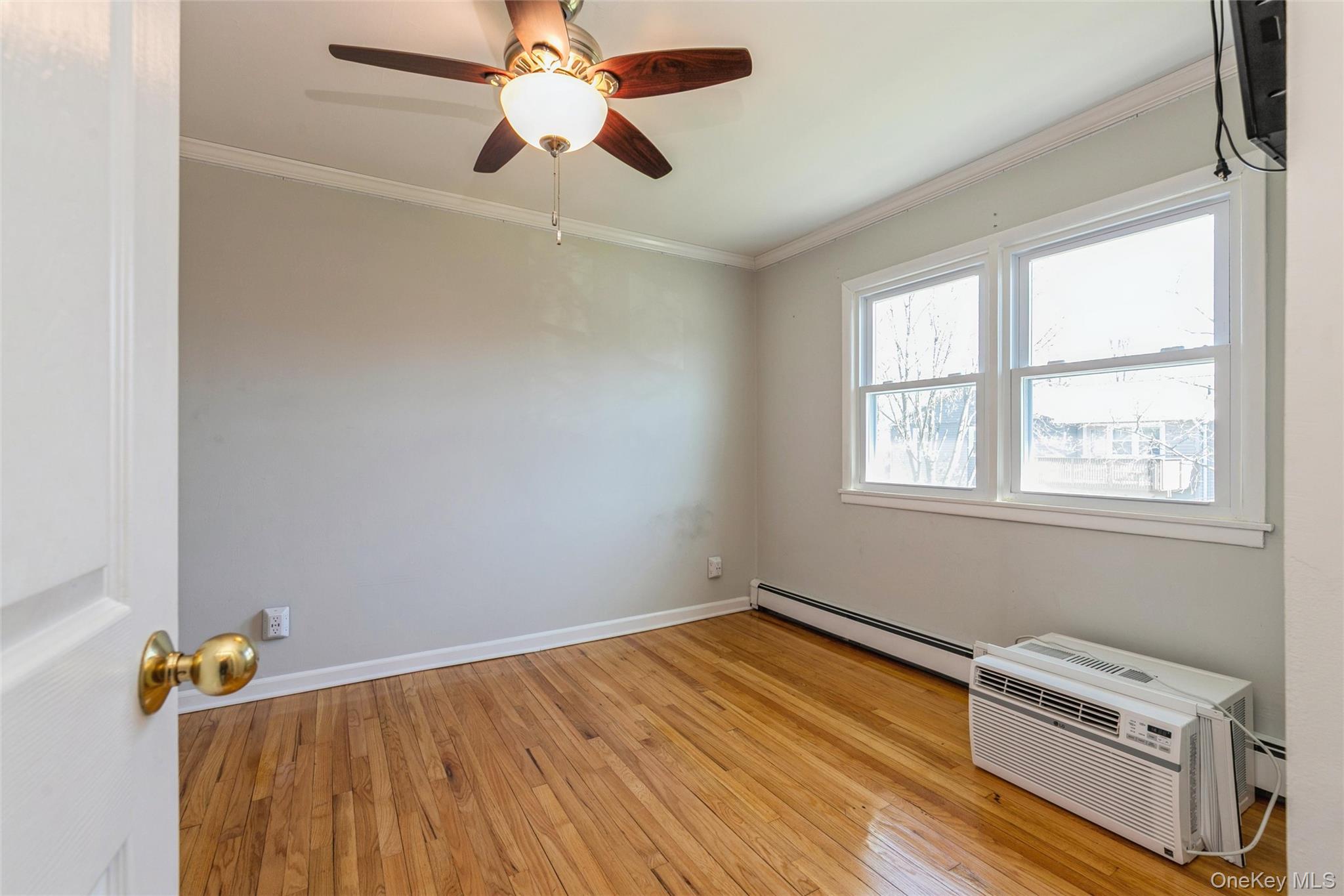 92 Cardinal Lane, Unit 92 Islip, NY 11751 - Photo 27 of 36 a room with a wooden floor and a window