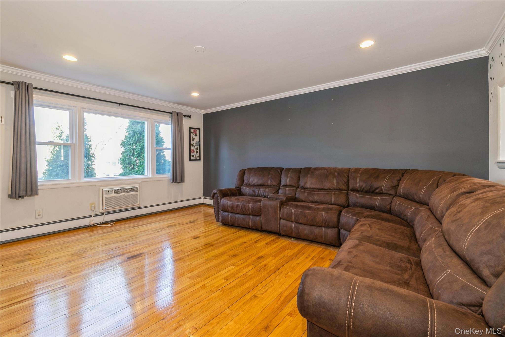 92 Cardinal Lane, Unit 92 Islip, NY 11751 - Photo 3 of 36 a living room with a couch and a large window