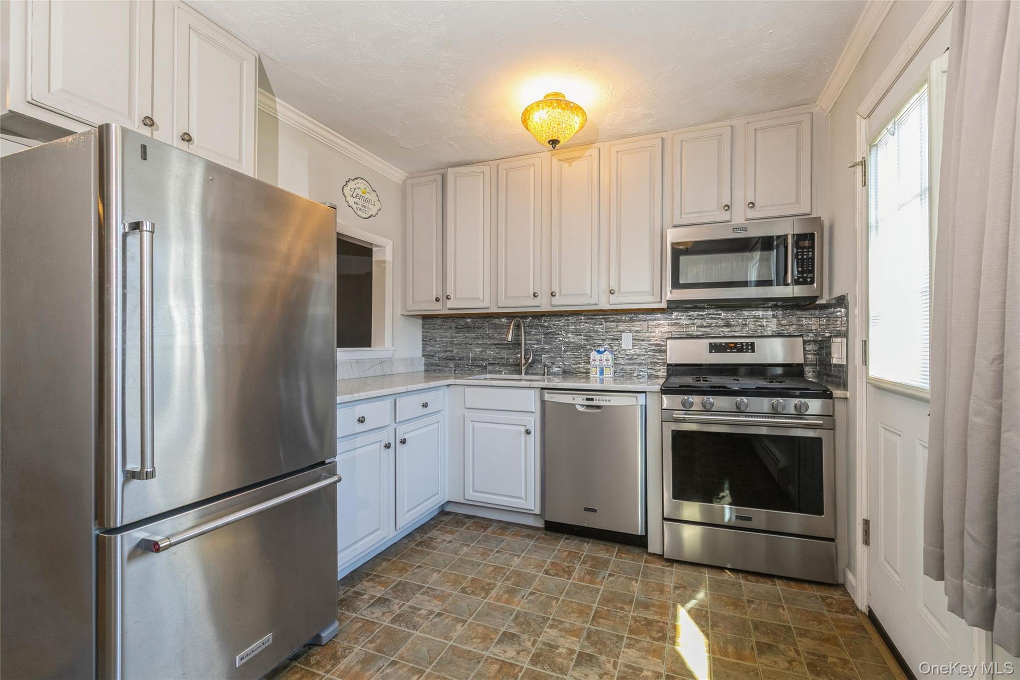 92 Cardinal Lane, Unit 92 Islip, NY 11751 - Photo 5 of 36 a kitchen with stainless steel appliances granite countertop a refrigerator sink and stove