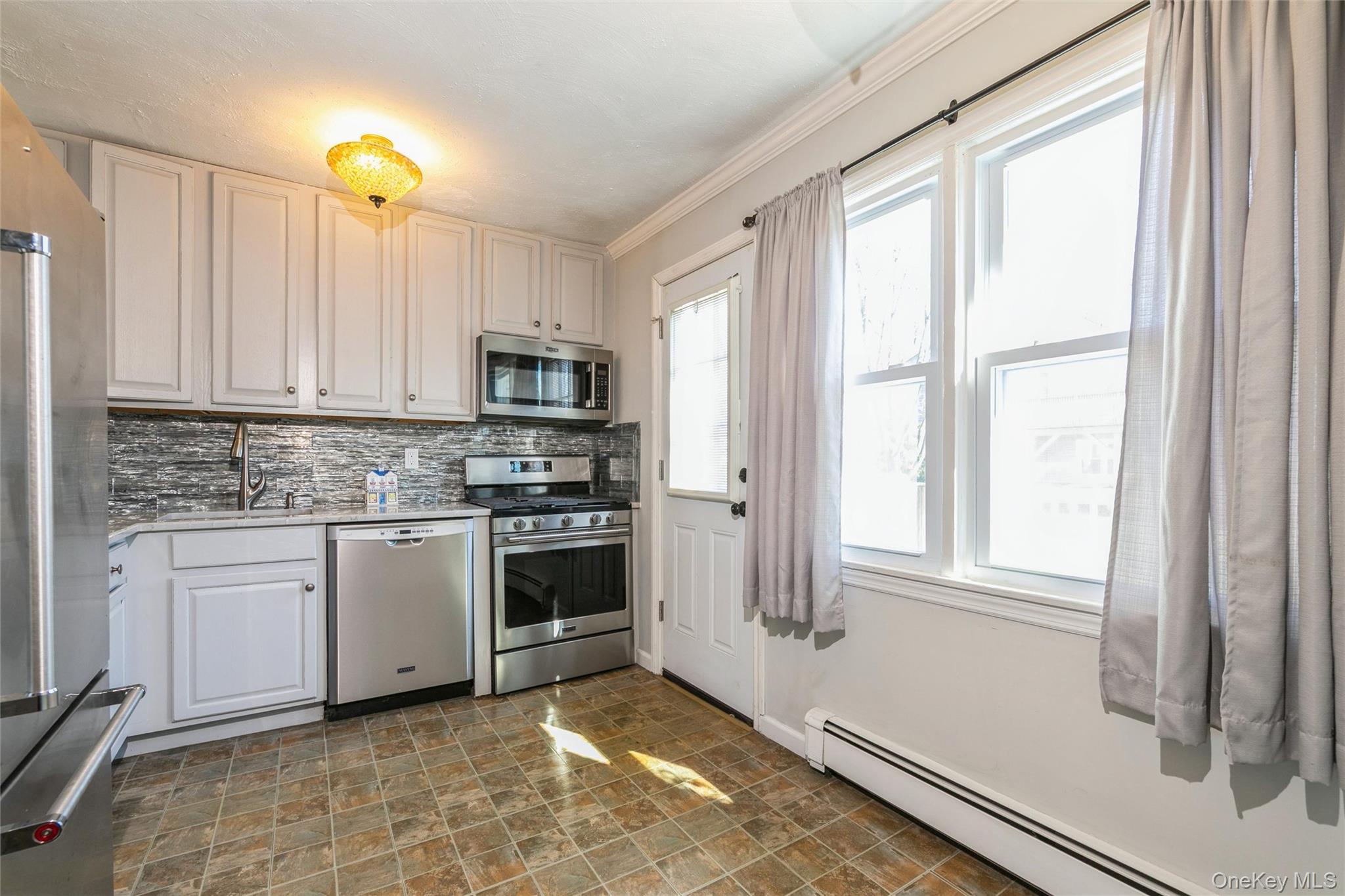 92 Cardinal Lane, Unit 92 Islip, NY 11751 - Photo 6 of 36 a kitchen with granite countertop a stove a sink and a refrigerator