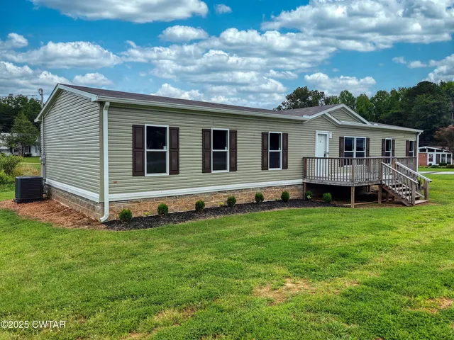 a house with green field in front of it